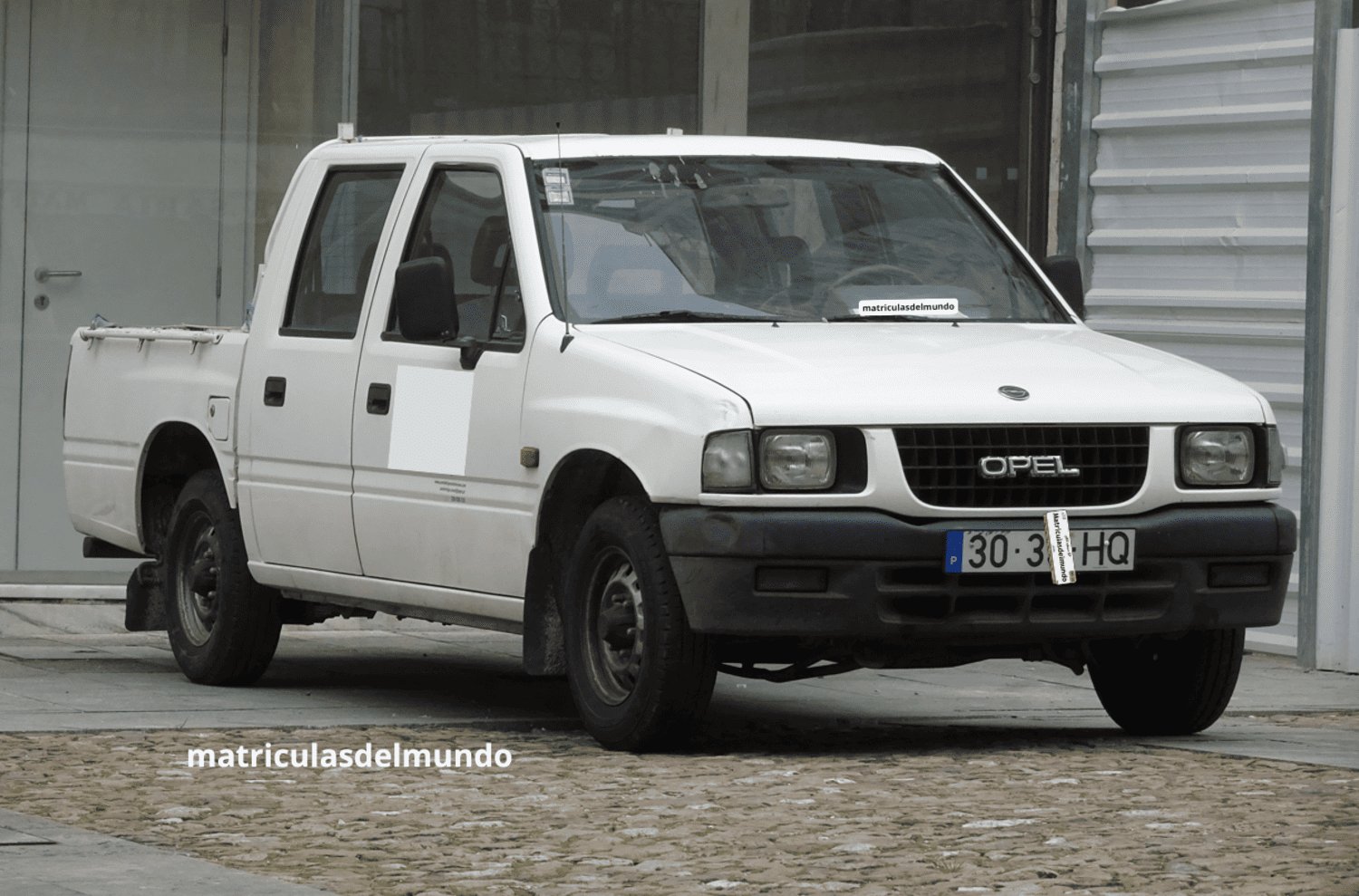 Opel Campo de color blanco aparcada en una obra con antigua matrícula blanca de Portugal