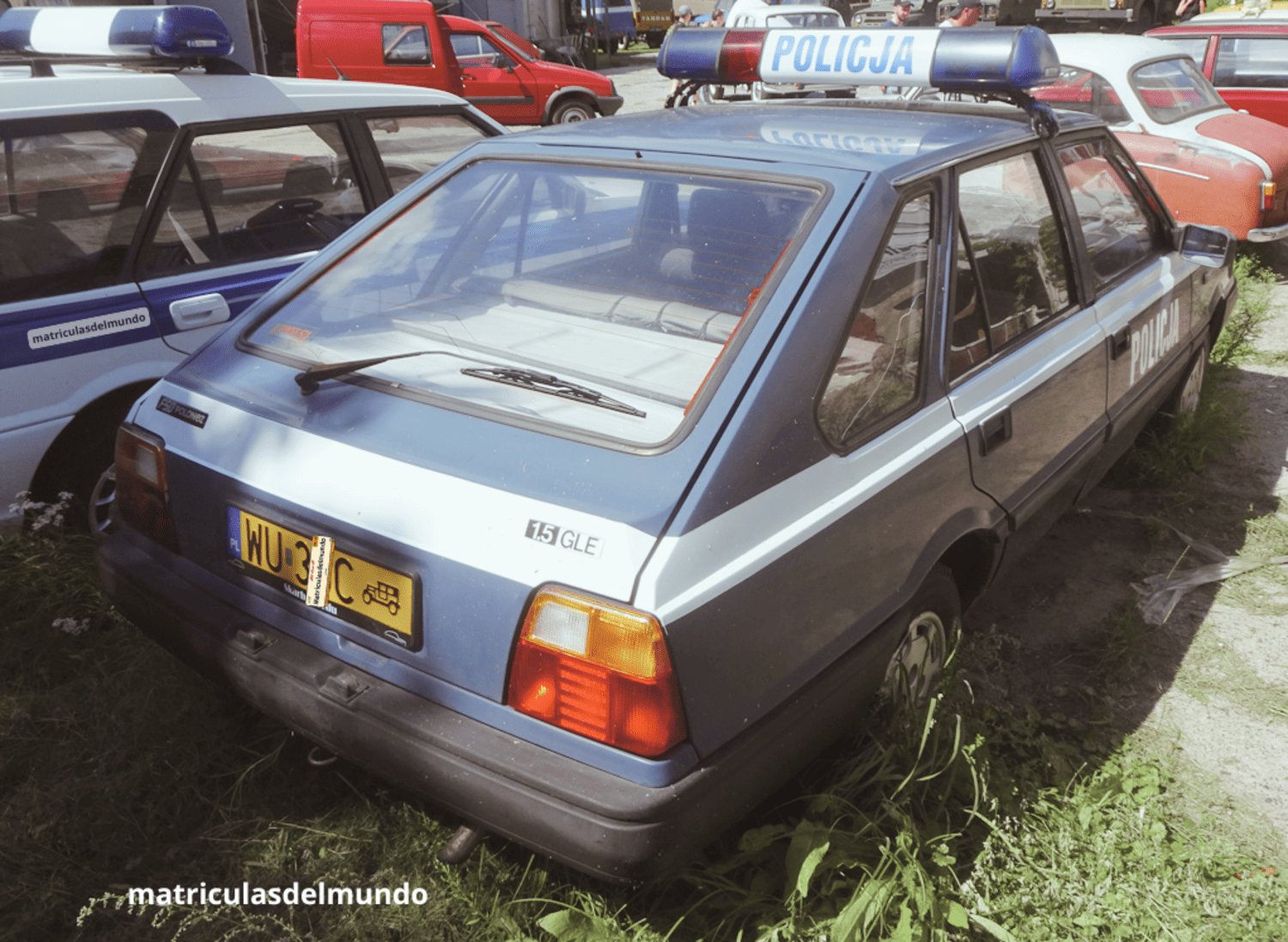 Antiguo FSO Polonez 1.5GLE de la policía de Polonia con sirenas y de color azul en un museo de coches viendo una Citroen C15 roja en el fondo