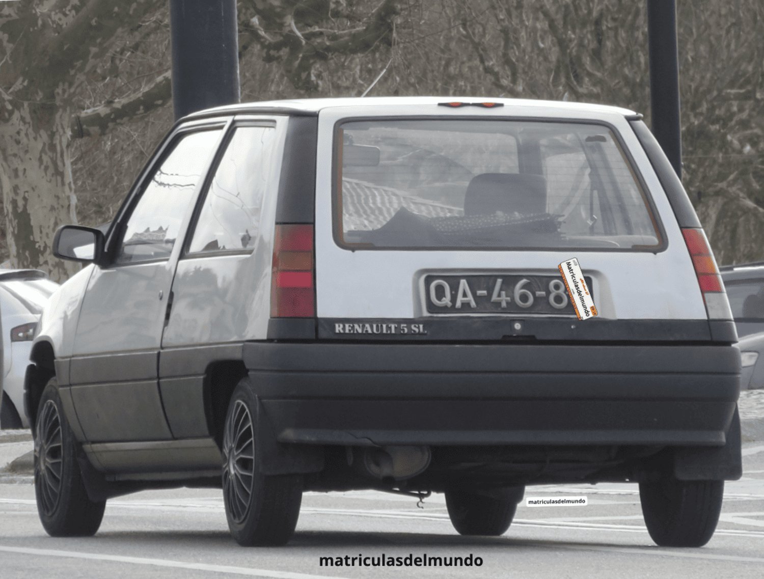 Renault 5SL gris original con matrícula portuguesa y números en relieve con letras QA en circulación en una calle de Lisboa