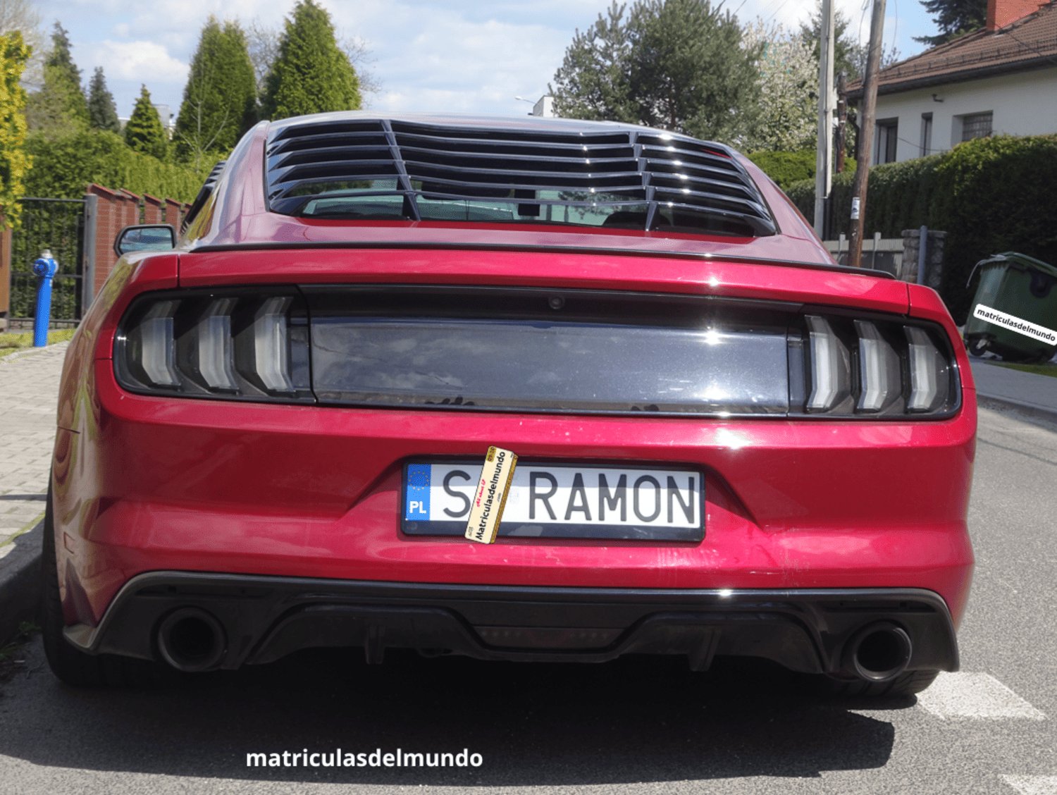 Ford Mustang rojo deportivo con matrícula personalizada RAMON de Polonia actual aparcado en una calle y con una boca de incendios azul