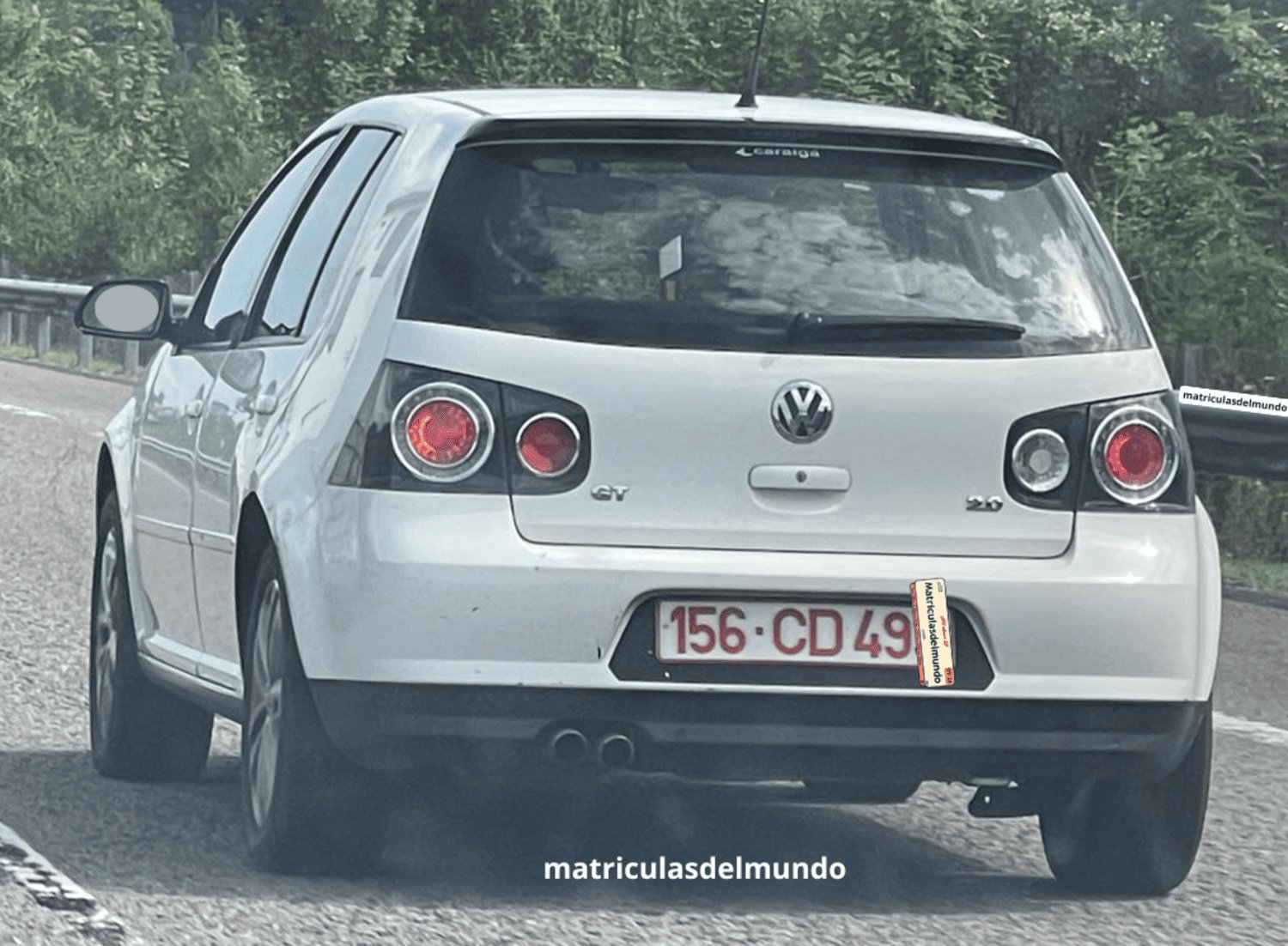 Volkswagen Golf blanco de quinta generacion con pilotos traseros modificados y con matrícula del cuerpo diplomático de Portugal circulando por una autovía española